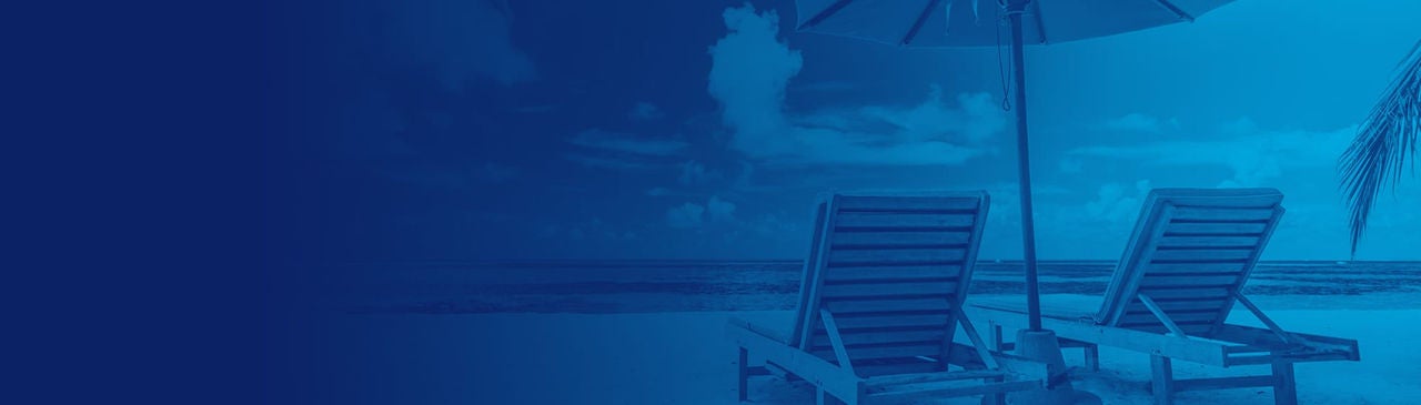White sandy beach with an empty sunbathing chairs and a large beach umbrella
