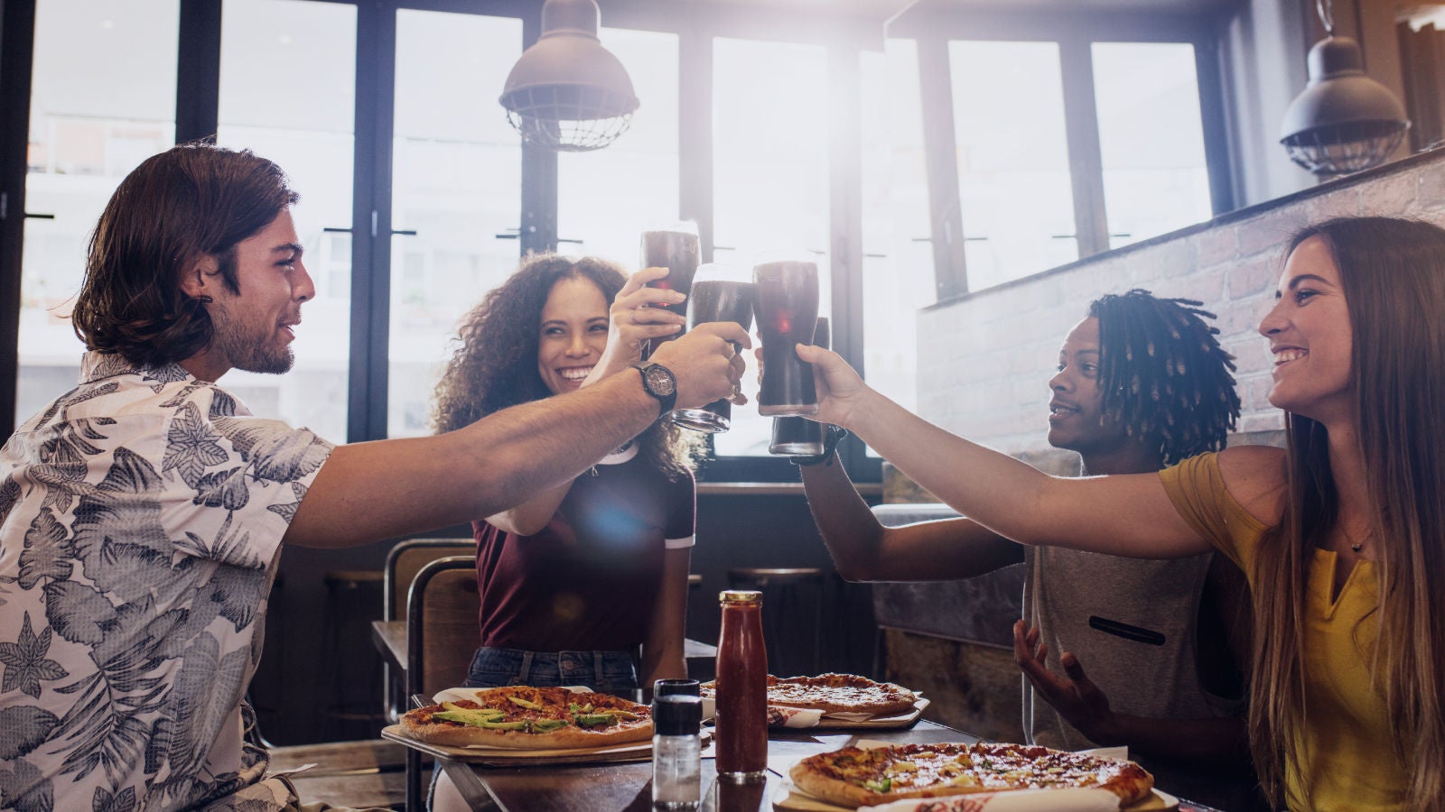 Group of friends saying "cheers" with a drink of Coke in their hand