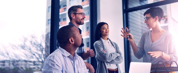 Colleagues in a meeting. Businesswoman in business casual clothing leading