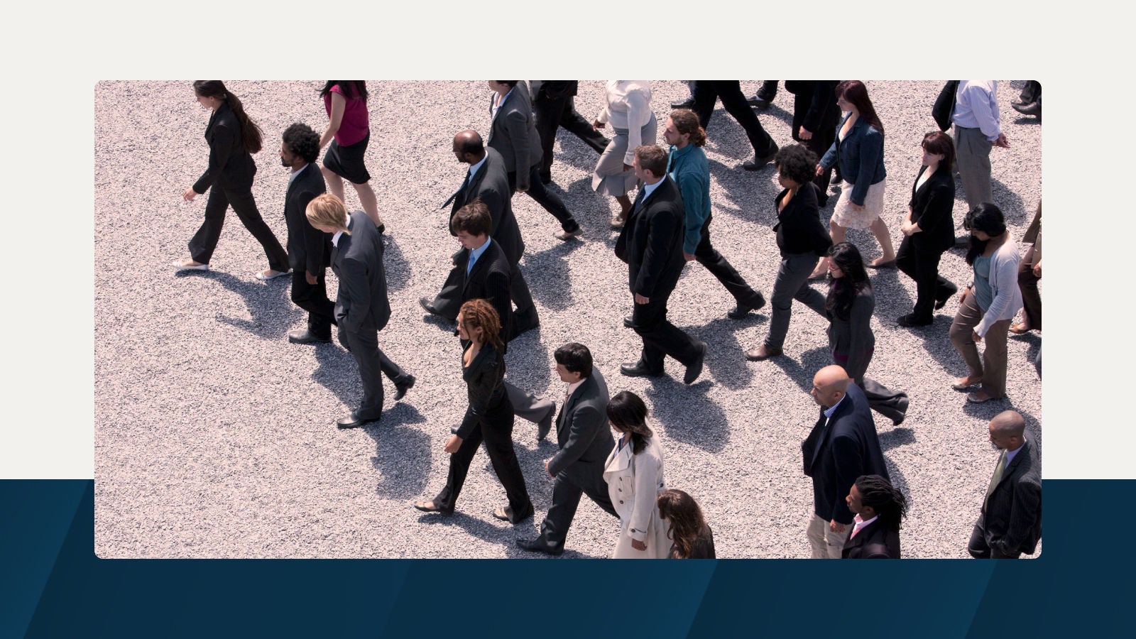 A group of business professionals walking in unison on a gravel path, symbolizing workforce movement and strategic planning.