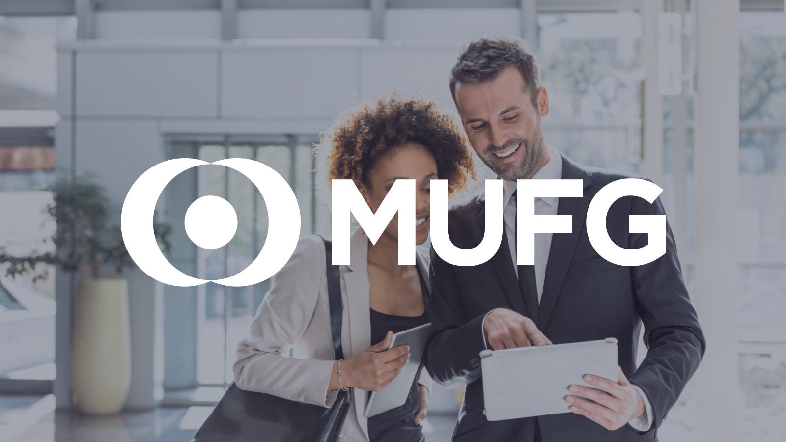 Graphic:MUFG logo overlayed on coworkers looking at tablet