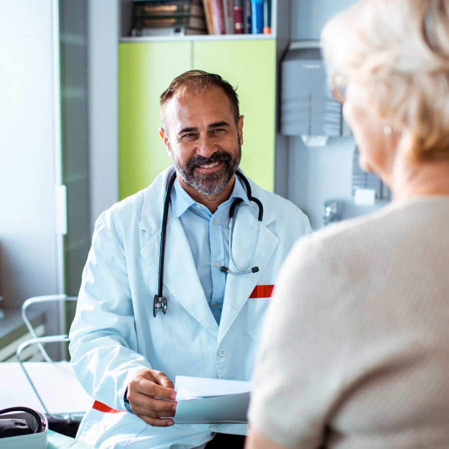 A man wearing a white coat stands confidently, showcasing professionalism and expertise in his field.