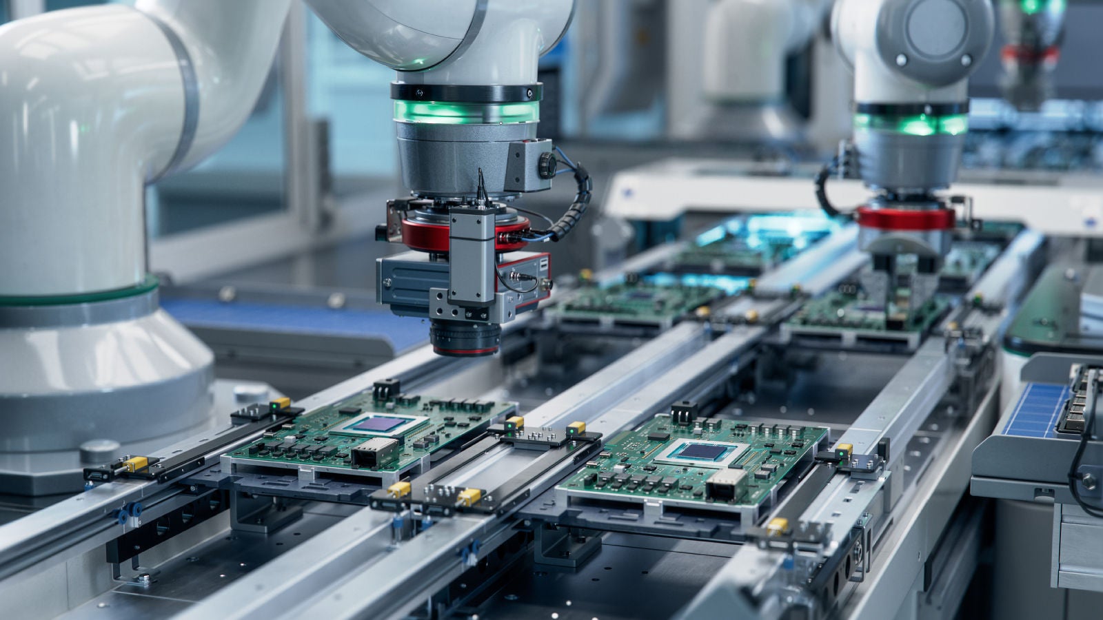 Robotic arms assembling circuit boards on an automated production line.