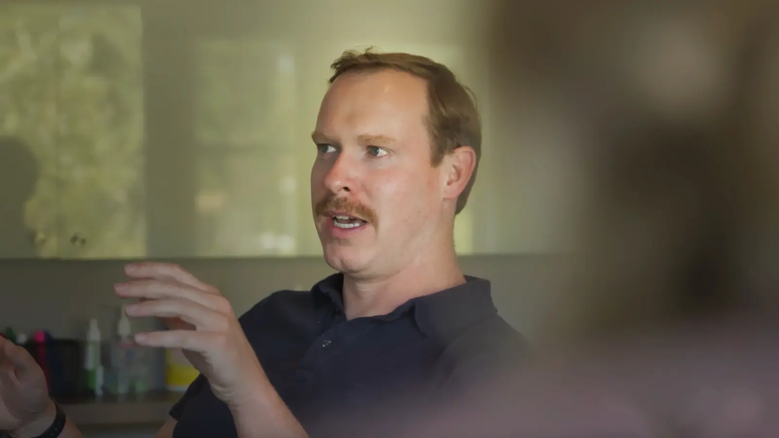 Picture of man with mustache talking to someone