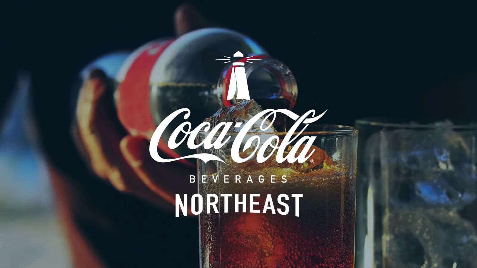 Coca-Cola Beverages Northeast Logo displayed center. A Coca-Cola bottle being poured over ice in a glass with a dark background.