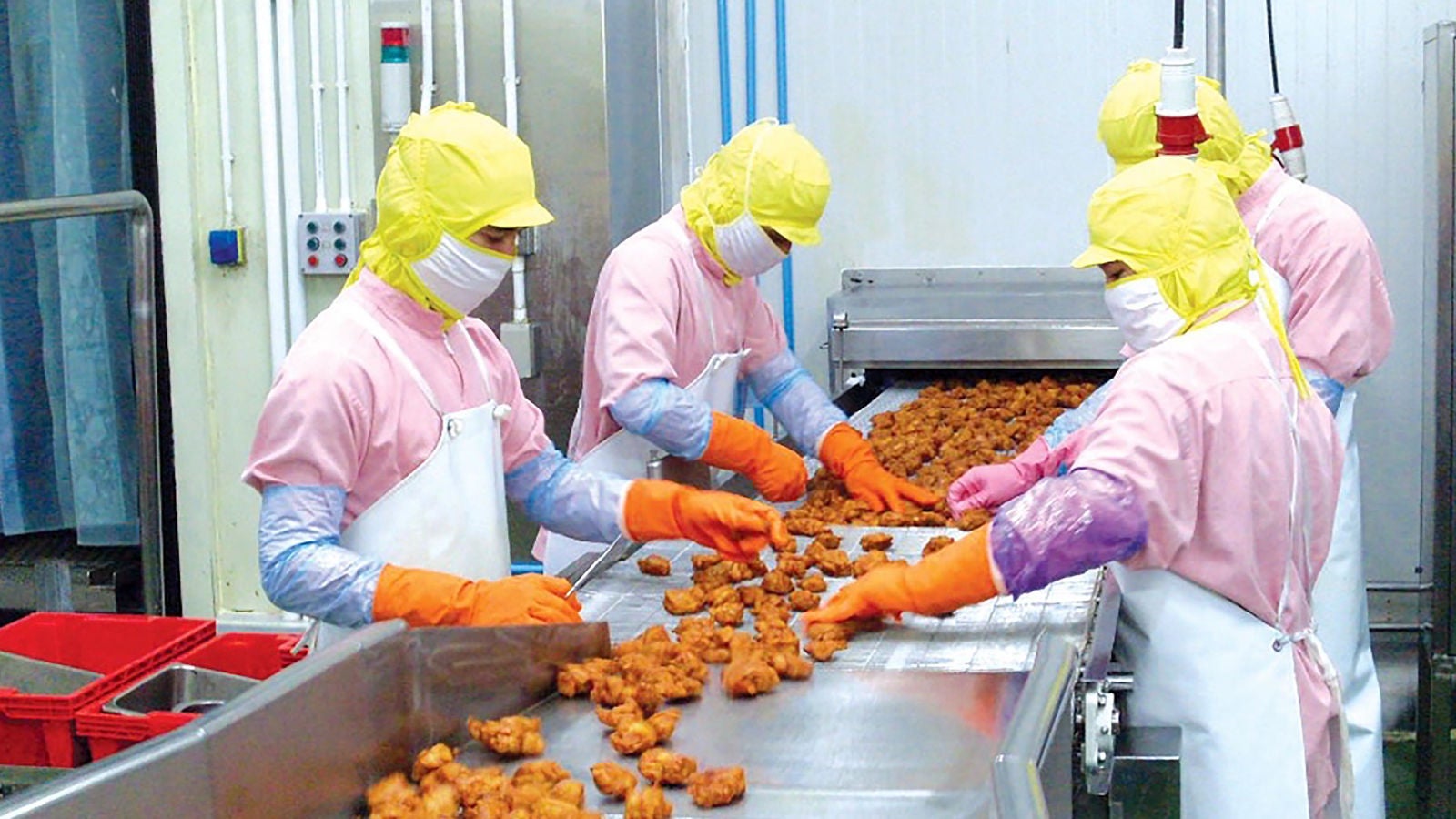 コンベヤー ベルトで商品の仕分けをする味の素社の作業員