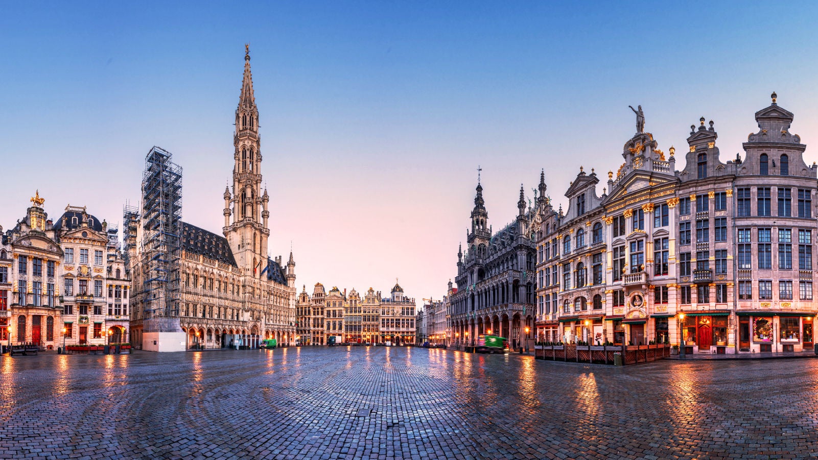 Anaplan event image for Connect 2025 Brussels. A panoramic view of the Grand Place at twilight, showcasing ornate historic buildings with golden accents and a wet cobblestone plaza reflecting the soft evening light.