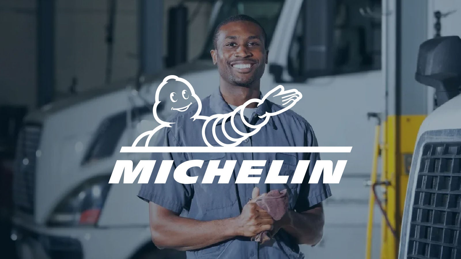 Michelin Logo displayed center. A smiling mechanic in a workshop with trucks in the background.