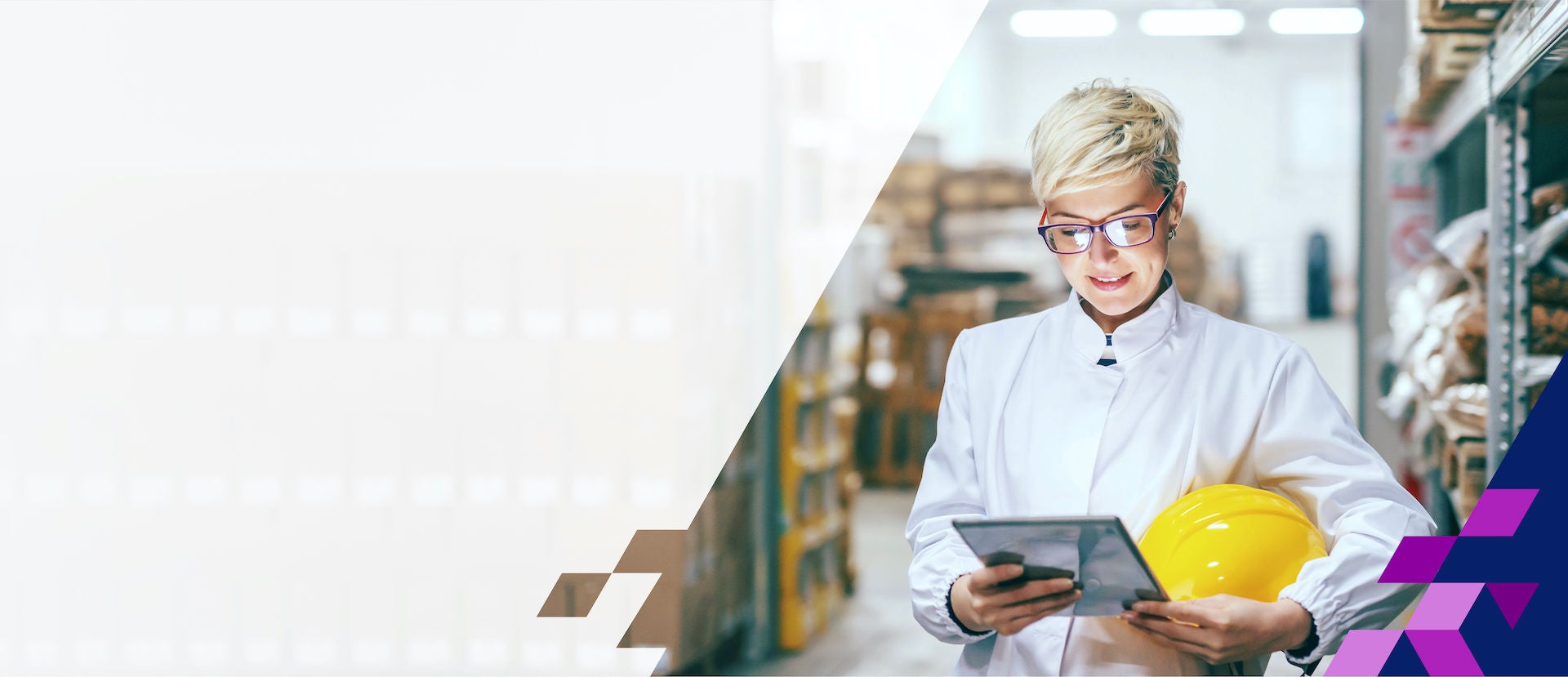 Woman in warehouse smiling while looking at a tablet