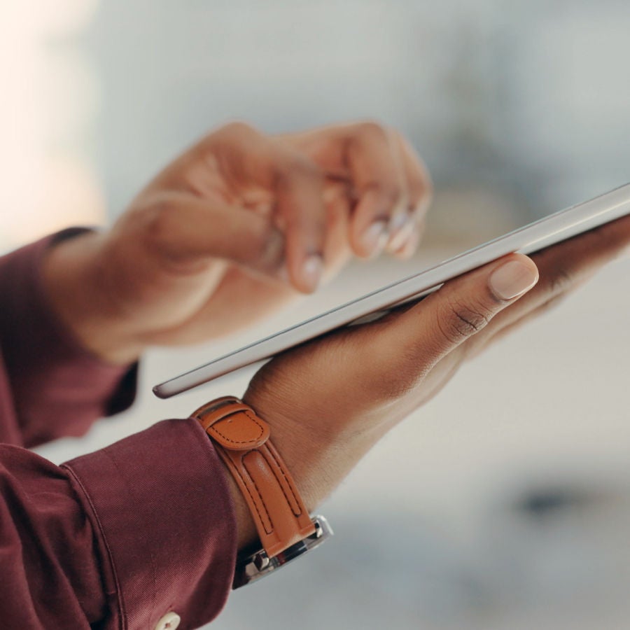 A hand holding a tablet computer, emphasizing the interaction between the user and the digital device.