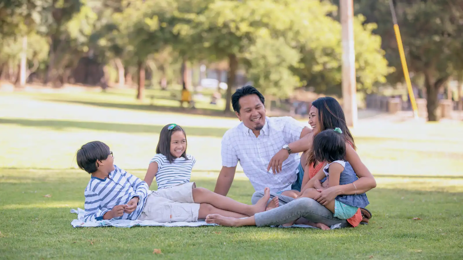 Family of five sitting together in a park