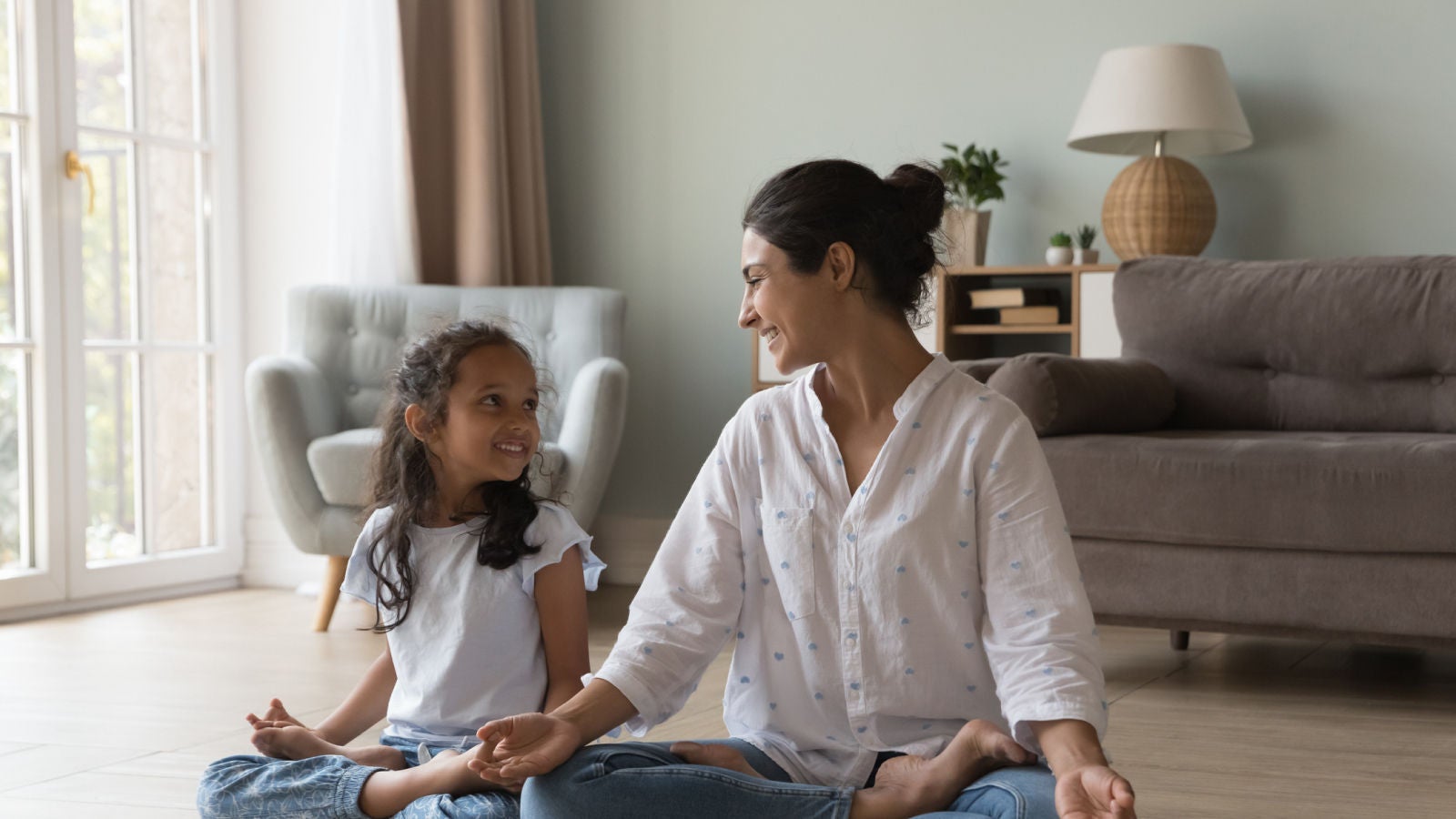 Mother and daughter sitting cross-legged on the floor