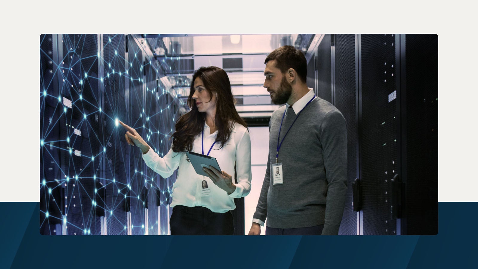 Two telecommunications professionals in a data center analyzing a glowing digital network interface on server racks.
