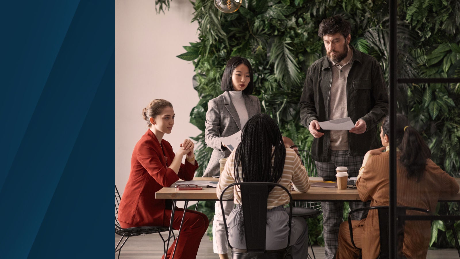 The image shows a team gathered around a table discussing documents, symbolizing strategic planning and sales collaboration.