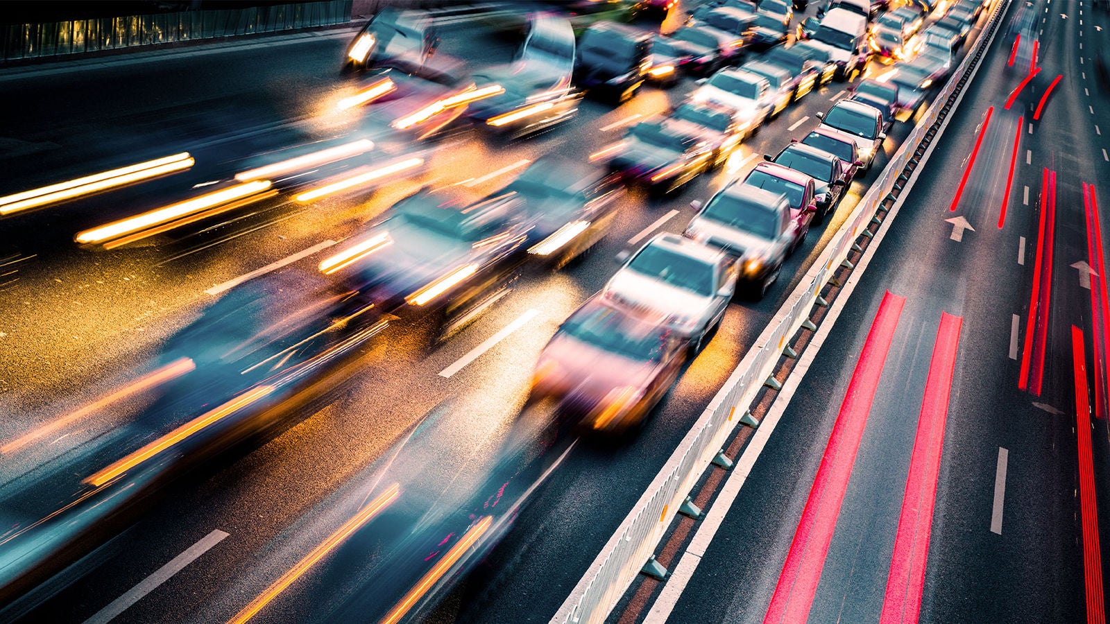 A motion-blurred image of heavy traffic on a highway at night, with streaks of red and yellow lights illustrating speed and congestion.