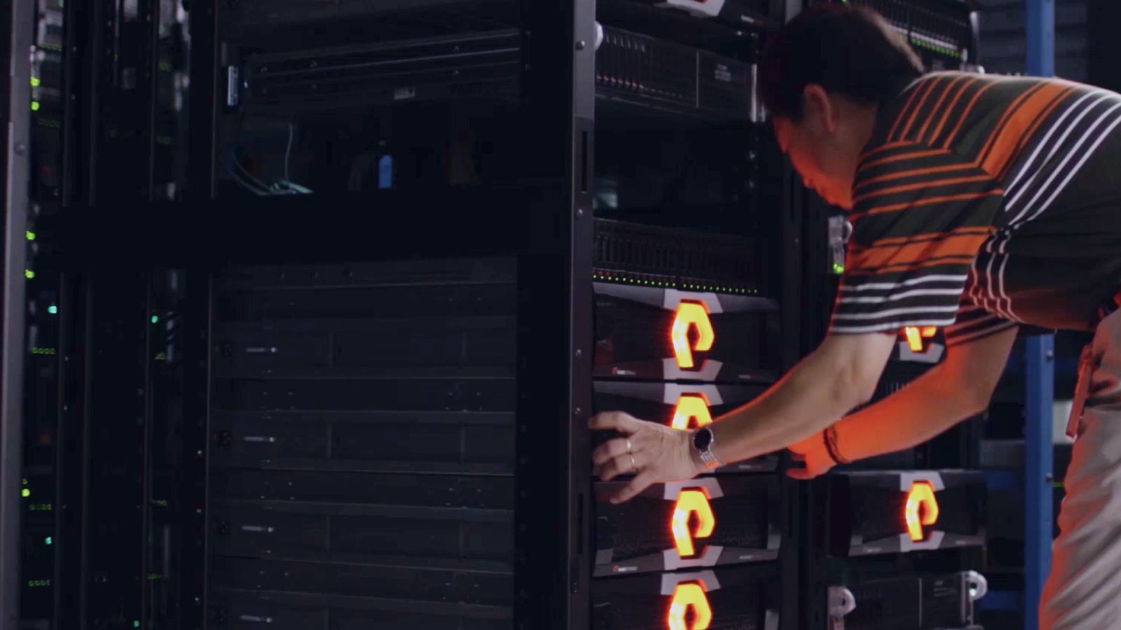 Man hunched over working on a computer mainframe
