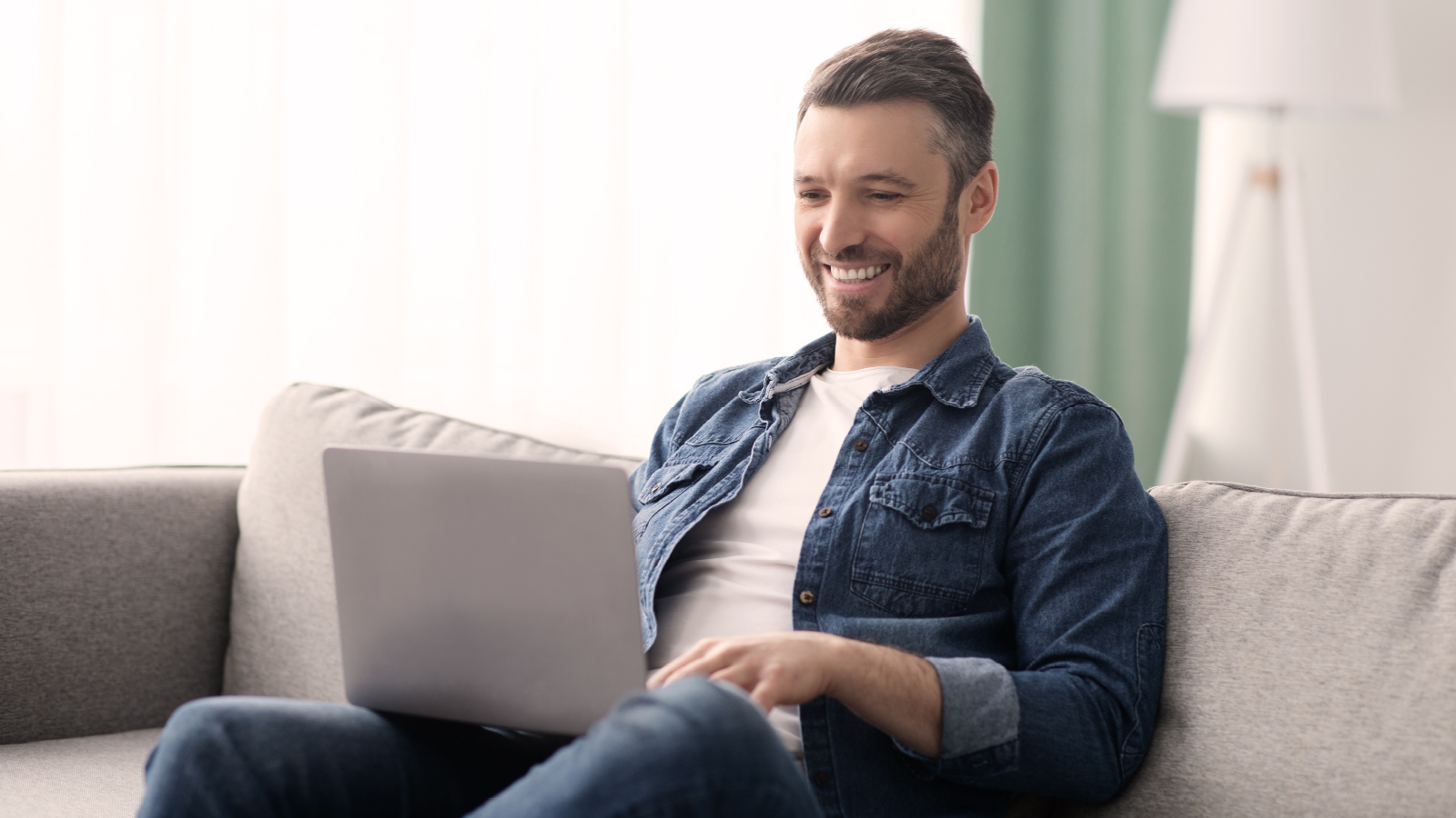 LinkedIn Customer Story Lifestyle Image Man on couch working on laptop