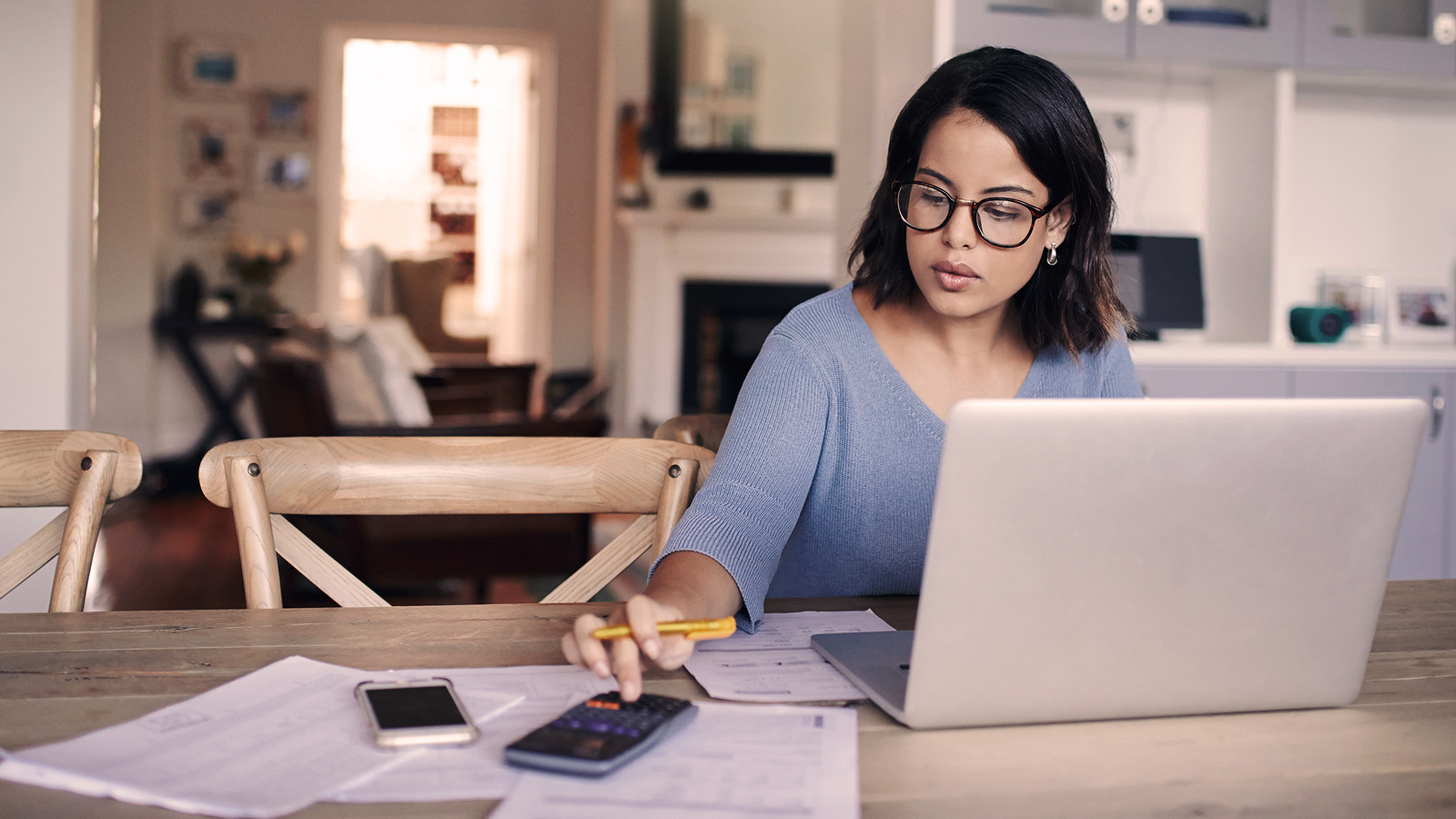 Anaplan eBook on budgeting best practices. The text highlights budgeting strategies, with an image of a woman working at a laptop, referencing notes and using a calculator at a kitchen table.