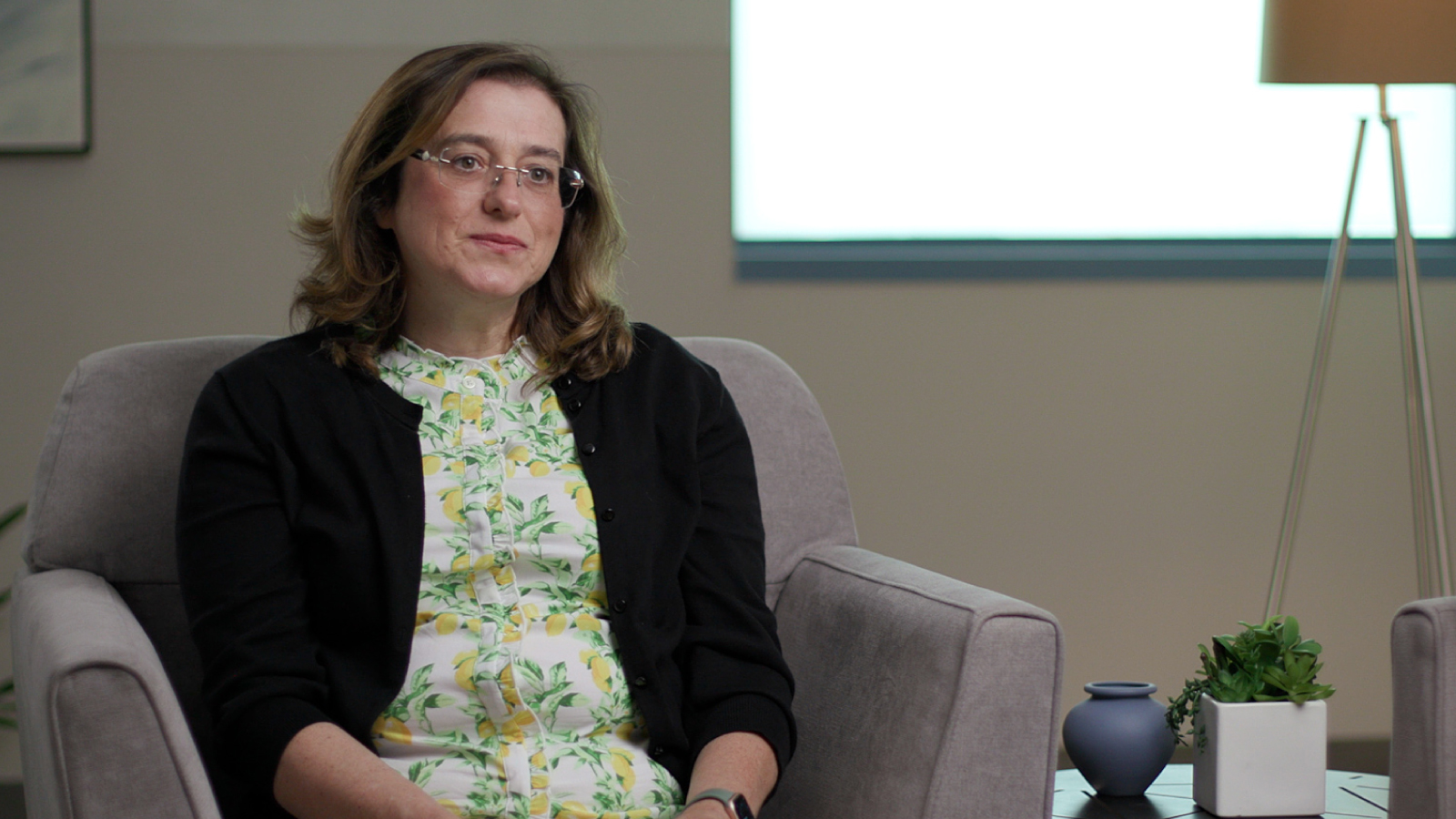 Businesswoman sitting in floral blouse/business attire for interview