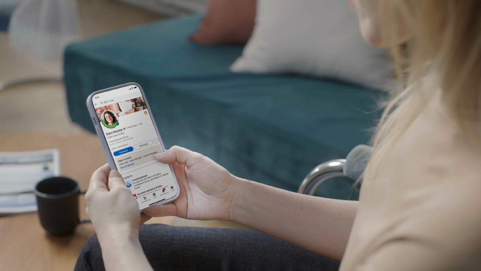 Image of woman looking at a LinkedIn profile on her smartphone