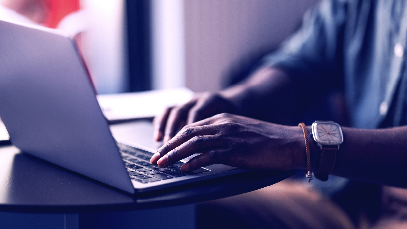 Person's hands typing on a laptop