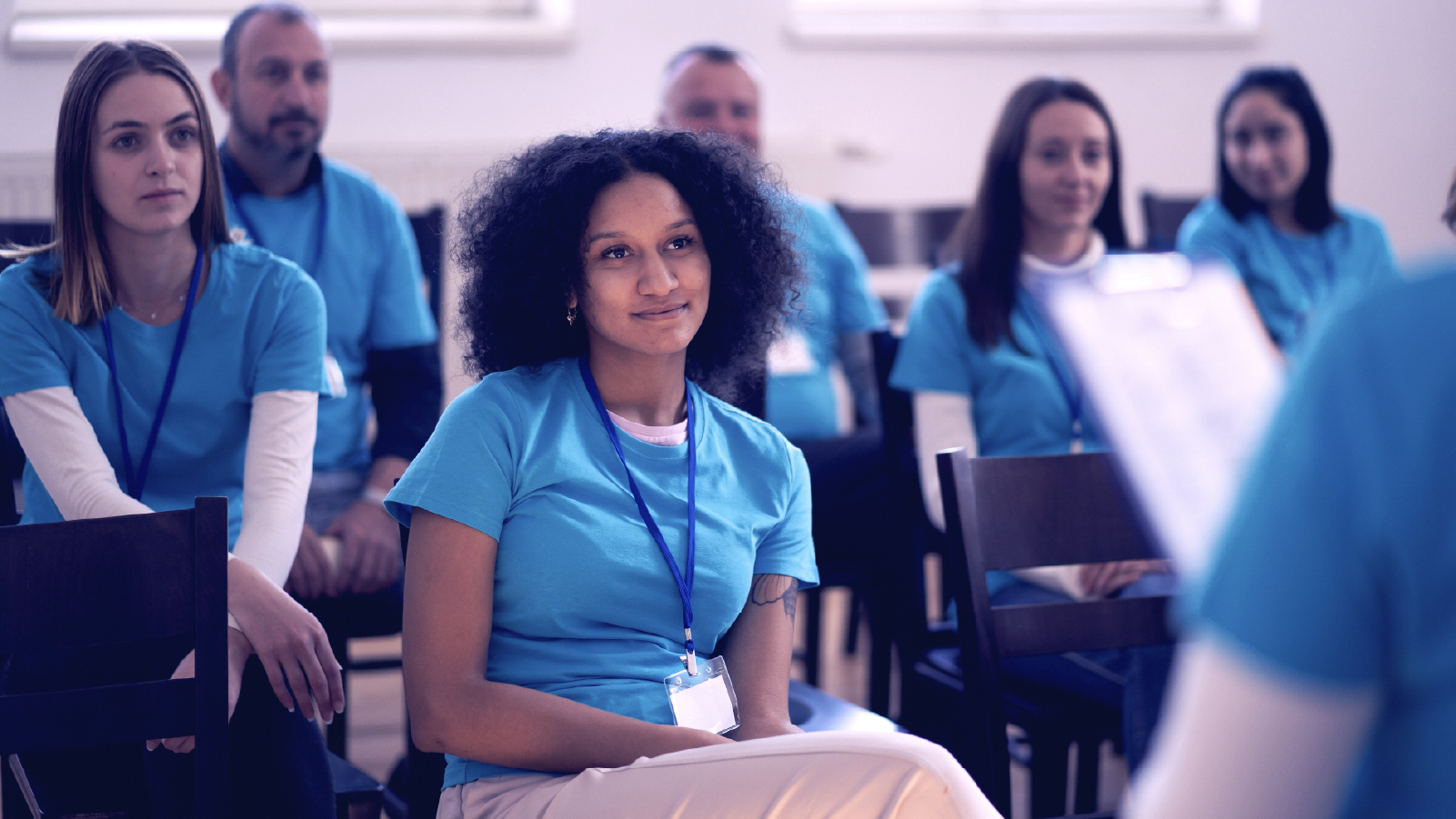 Group of people sitting around listening to a speaker