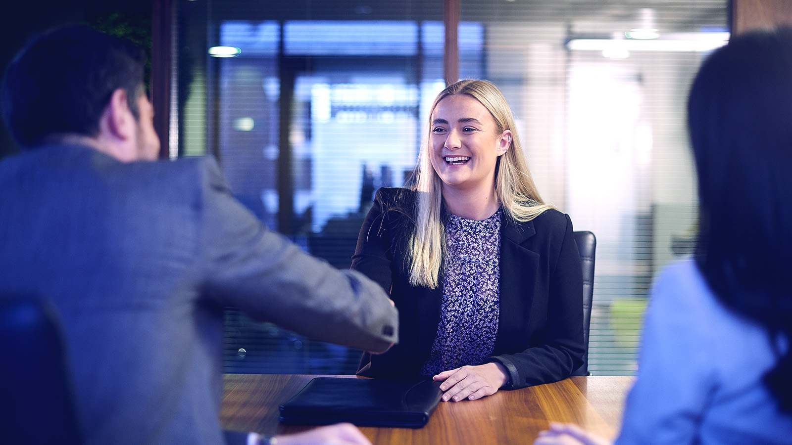 A man and women interviewing a female in a conference room.