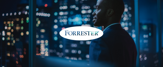 Business man in office building looking out at their city, night setting, with Forrester logo overlayed atop