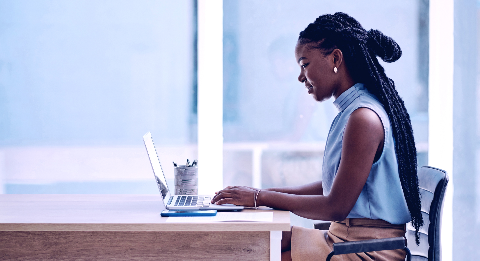 Woman working on laptop in office setting