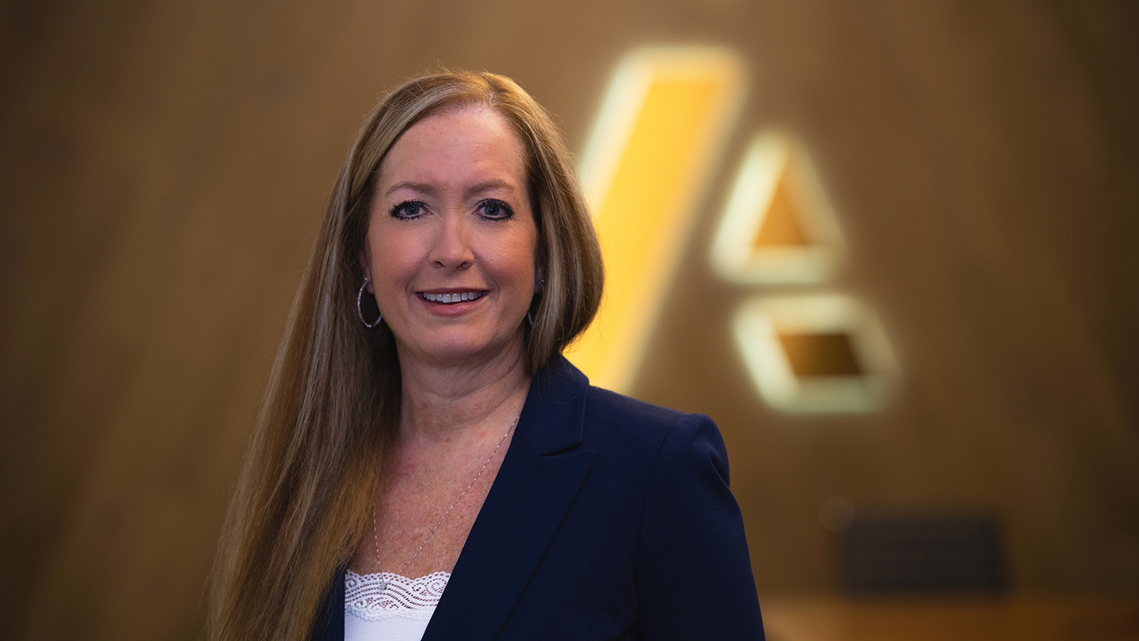 Carey Pellock — businesswoman dressed in suit standing in front of Anaplan logo