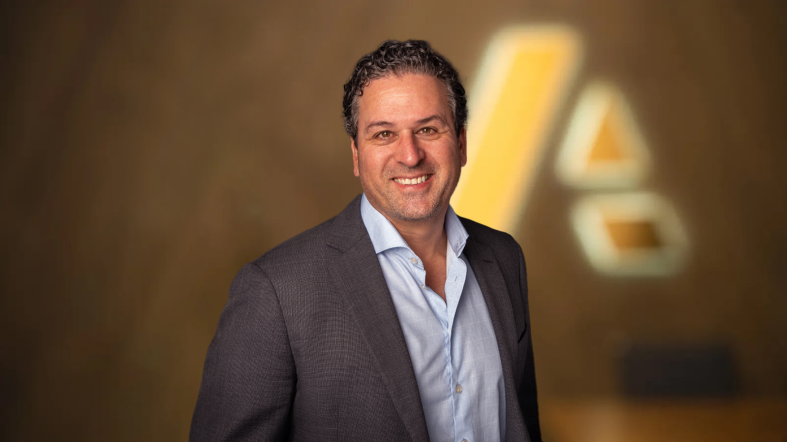 Ivo Bauermann — businessman dressed in suit standing in front of Anaplan logo